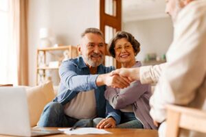 A couple reviews insurance documents and a home inventory checklist at their dining table.